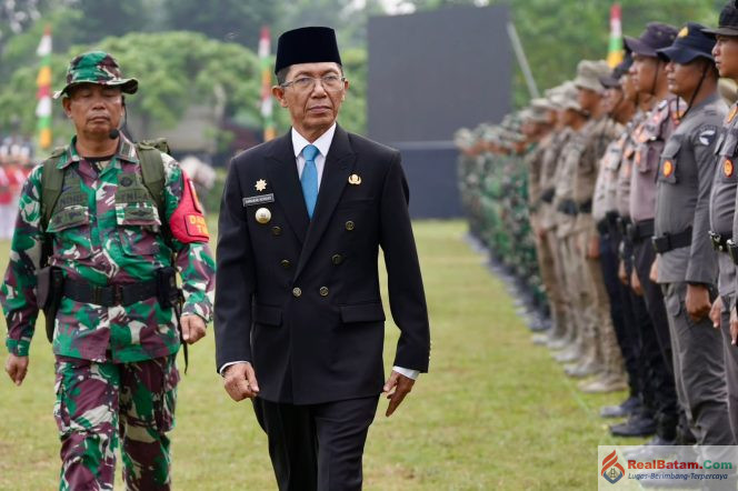 
					Aksranews.com. Batam-Wali Kota Batam, Amsakar Achmad, mengajak TNI, pemerintah, dan masyarakat memperkuat kolaborasi serta gotong royong dalam mendukung pembangunan daerah. Hal itu disampaikan Amsakar saat membuka TNI Manunggal Membangun Desa (TMMD) ke-130 Tahun Anggaran 2026 di Lapangan Garuda, Kelurahan Mangsang, Kecamatan Sei Beduk, Selasa (13/10/2026).

Dalam kegiatan tersebut, Amsakar bertindak sebagai inspektur upacara. Ia menyampaikan apresiasi kepada jajaran TNI, khususnya Kodim 0316/Batam, yang terus berperan aktif dalam pembangunan dan membantu masyarakat secara langsung.

Menurut Amsakar, pembangunan daerah tidak dapat hanya mengandalkan pemerintah. Diperlukan kebersamaan, kepedulian, dan semangat saling membantu agar hasil pembangunan dapat dirasakan masyarakat.

Ia menegaskan, perkembangan Batam sebagai kota industri dan investasi harus berjalan seiring dengan peningkatan kesejahteraan warga. Keberhasilan pembangunan, kata dia, tidak hanya dilihat dari kemajuan fisik, tetapi juga dari manfaat yang dirasakan masyarakat dalam kehidupan sehari-hari.

“Bagi kami, Pemerintah Kota Batam, kegiatan seperti ini sangat berarti. Batam boleh terus berkembang sebagai kota industri dan investasi, tetapi kita tidak boleh melupakan bahwa ukuran keberhasilan pembangunan yang sesungguhnya adalah ketika masyarakat merasakan manfaatnya dan ambil bagian di dalam kehidupan sehari-hari,” ujar Amsakar.

Ia berharap pelaksanaan TMMD di Kelurahan Mangsang memberikan dampak nyata bagi masyarakat. Manfaat tersebut diharapkan tidak hanya berupa pembangunan sarana dan prasarana fisik, tetapi juga melalui kegiatan sosial yang mendekatkan pelayanan kepada warga.

Amsakar juga berpesan kepada seluruh personel Satuan Tugas (Satgas) TMMD agar mengutamakan kesehatan dan keselamatan selama bertugas serta membangun komunikasi yang baik dengan masyarakat. Ia optimistis kehadiran prajurit TNI akan disambut baik oleh warga Mangsang.

Kepada masyarakat, ia mengajak warga mendukung pelaksanaan TMMD dan menjaga semangat gotong royong. Menurutnya, keberhasilan program tersebut membutuhkan partisipasi masyarakat karena hasil pembangunan pada akhirnya ditujukan untuk kepentingan bersama.

“Saya percaya, ketika TNI, pemerintah, dan masyarakat sudah berjalan seiring, pekerjaan seberat apa pun akan menjadi lebih ringan. Mudah-mudahan kebersamaan yang kita bangun hari ini tidak hanya berhenti sampai program ini selesai, tetapi terus menjadi kekuatan dalam membangun Batam yang semakin maju dan masyarakatnya semakin sejahtera,” tuturnya.

Pembukaan TMMD ke-130 Tahun Anggaran 2026 di Kelurahan Mangsang ditandai dengan pengucapan basmalah oleh Amsakar. Kegiatan tersebut turut dihadiri jajaran Forum Koordinasi Pimpinan Daerah (Forkopimda) Kota Batam, pejabat di lingkungan Pemerintah Kota Batam, tokoh masyarakat, serta warga setempat. (Red)