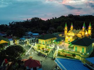 Komplek Balai Adat Pulau Penyengat di waktu malam dengan latar belakang Kota Tanjungpinang di waktu malam