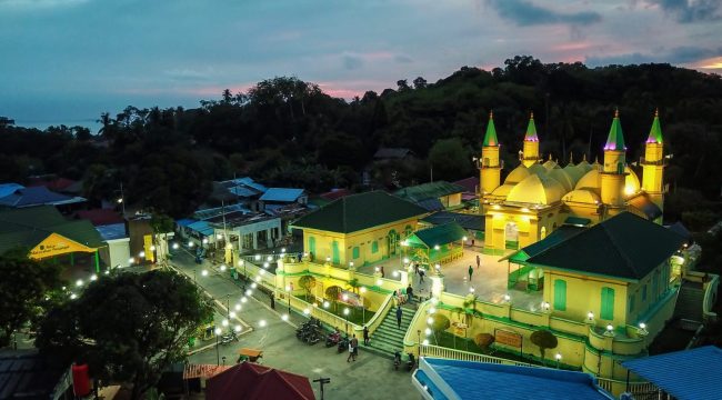 Komplek Balai Adat Pulau Penyengat di waktu malam dengan latar belakang Kota Tanjungpinang di waktu malam